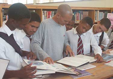 Bibliotekarien Wayne Kaputo hjlper ngra skolpojkar p West End Library i Nelson Mandela Metro